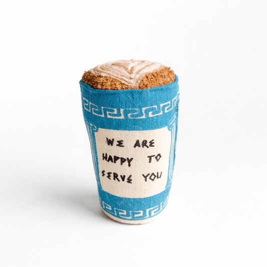 Handmade fabric Greek coffee cup  with blue-and-white print and soft latte art top on a clean white studio background.