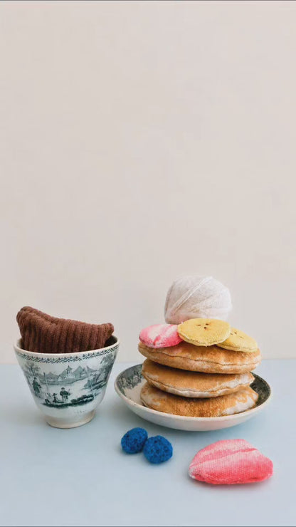 Handmade pancake play food set made from soft fabric, with textile pancakes, fruit toppings and whipped cream for pretend play kitchens.