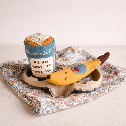 Toy bread and banana on a floral tray with a white background
